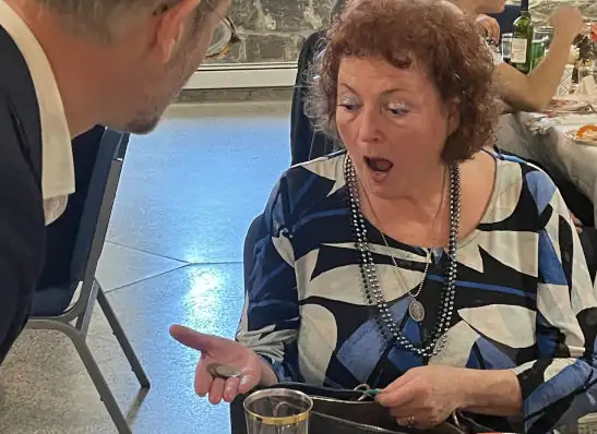 Woman reacting with surprise to a close-up coin magic trick