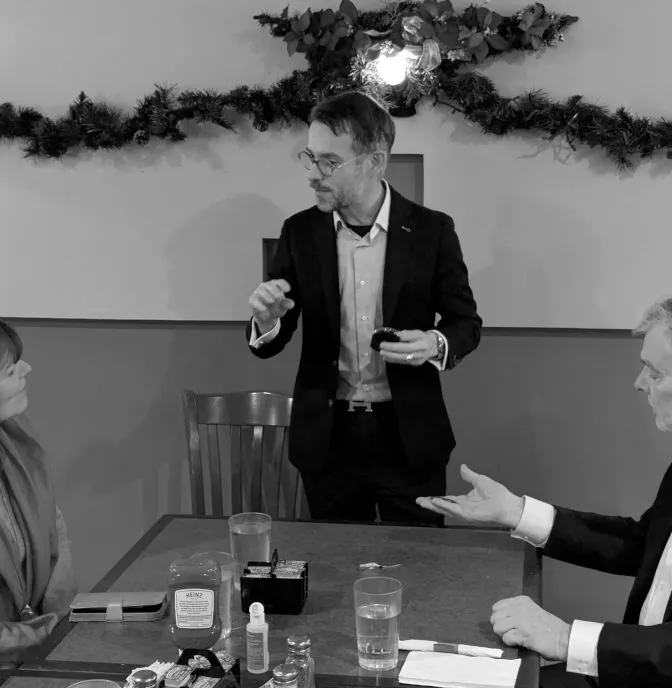 Magician performing close-up magic for guests during a dinner