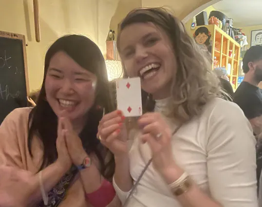 Guests smiling and holding a playing card after a close-up magic trick