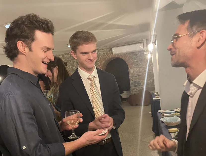 Magician performing a close-up card trick for guests during a cocktail hour
