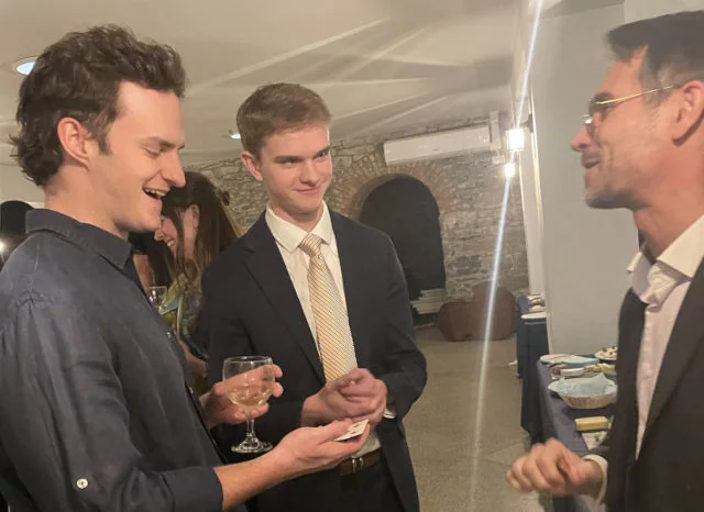 Magician performing a close-up card trick for guests during a cocktail hour