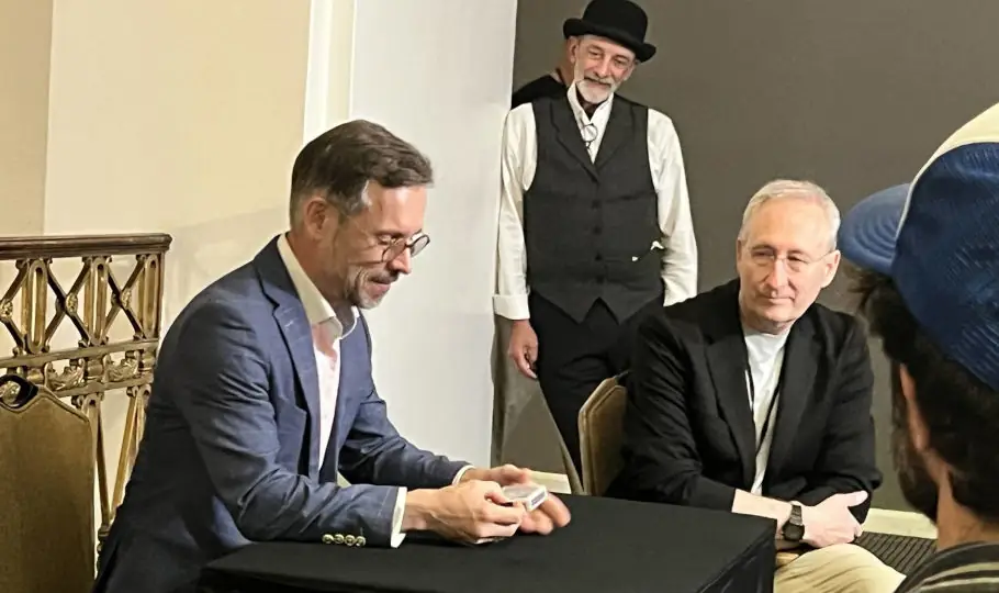 Magician performing a parlor magic show for a seated audience