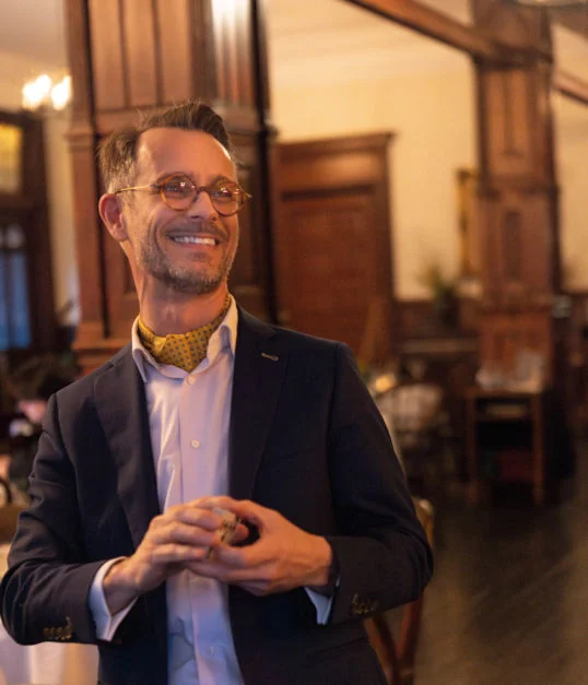 Magician smiling while performing close-up magic at an upscale event