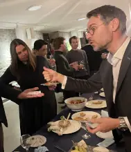 Magician performing a close-up card trick for a small group of guests