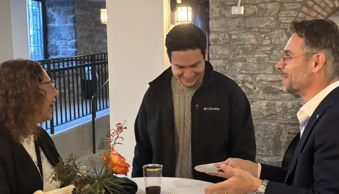 Magician performing a close-up card trick for a small group of guests