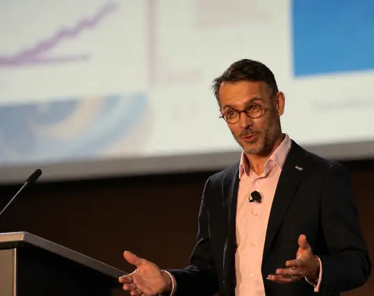 Magician speaking on stage during a corporate presentation