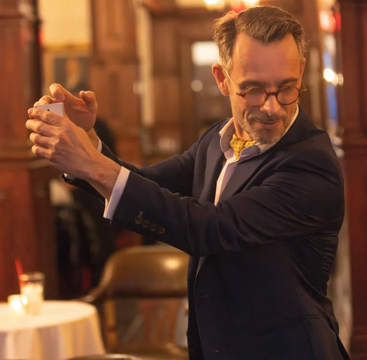 Elegant magician performing a close-up card routine in a luxury lounge setting