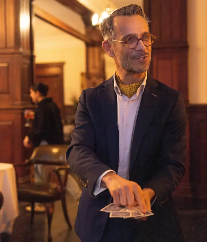Magician performing a close-up card trick at an upscale indoor event