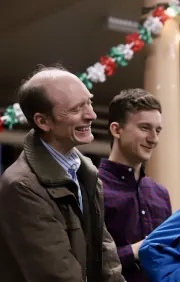 Audience members smiling and reacting during a family-friendly magic performance