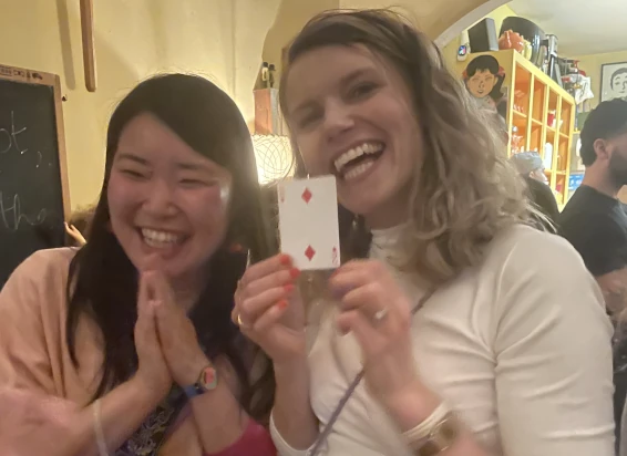 Guests smiling and holding a playing card after a close-up magic trick
