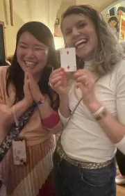 Guests smiling and holding a playing card after a close-up magic trick