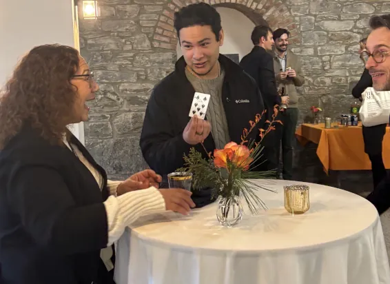 Guests reacting to an interactive close-up magic performance during a cocktail reception