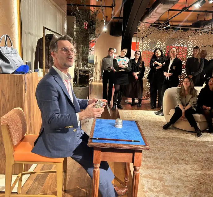 Magician performing an intimate close-up magic routine for guests at a luxury corporate event