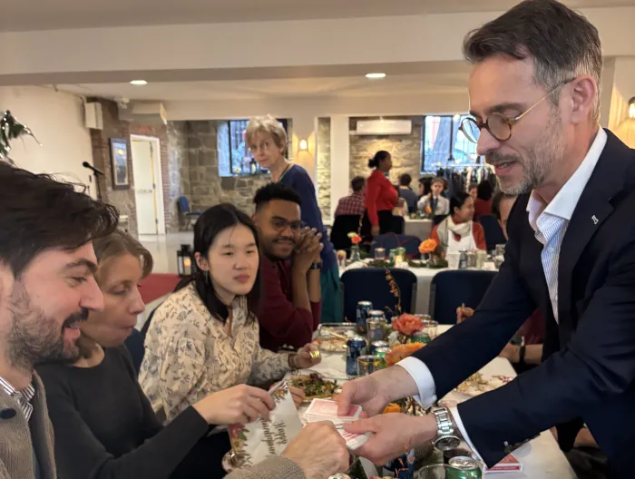 Magician performing a close-up card trick for guests at a dinner table