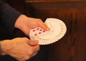 Close-up of FX spreading a deck of playing cards between his hands