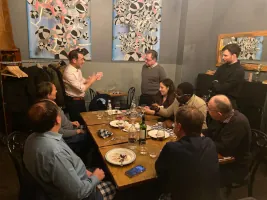 FX performing close-up magic for guests gathered around a dinner table